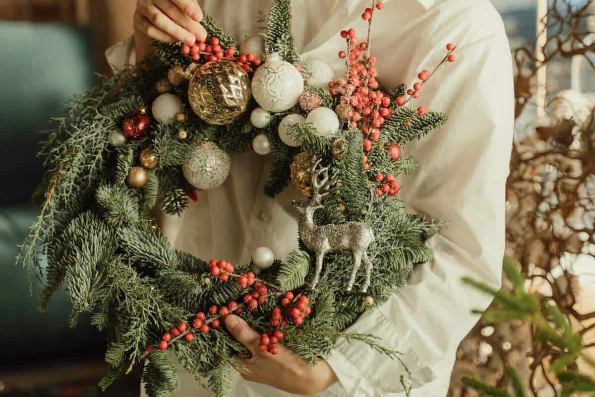 A woman decorating a wreath